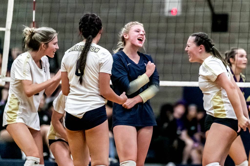 Arlingtons Chloe Lewis, facing, leads a cheer for a point against Lake Stevens on Sept. 9 at Arlington High School. (Kevin Clark / The Herald)