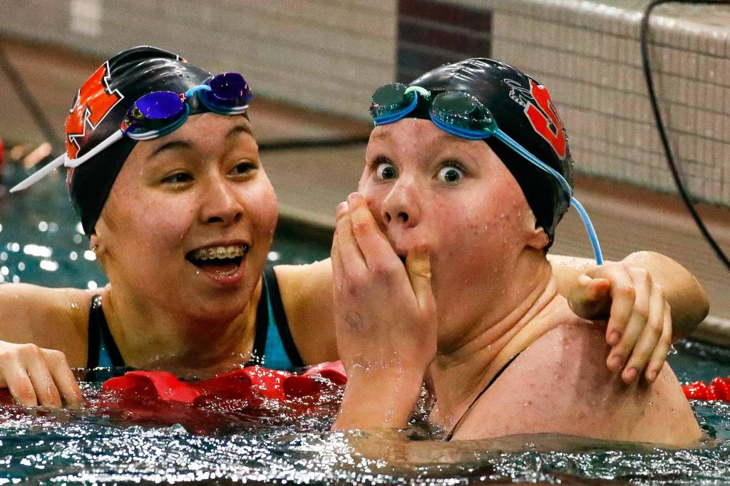 Snohomishs Mary Clarke (right) reacts to breaking the Class 3A District 1 meet record in the 100-yard freestyle at Snohomish Aquatic Center on Nov. 6, 2021. (Kevin Clark / The Herald)