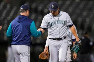 Seattle Mariners manager Scott Servais, left, takes the ball from pitcher Erik Swanson during the seventh inning of the team's baseball game against the Oakland Athletics in Oakland, Calif., Wednesday, Sept. 21, 2022. (AP Photo/Jeff Chiu)