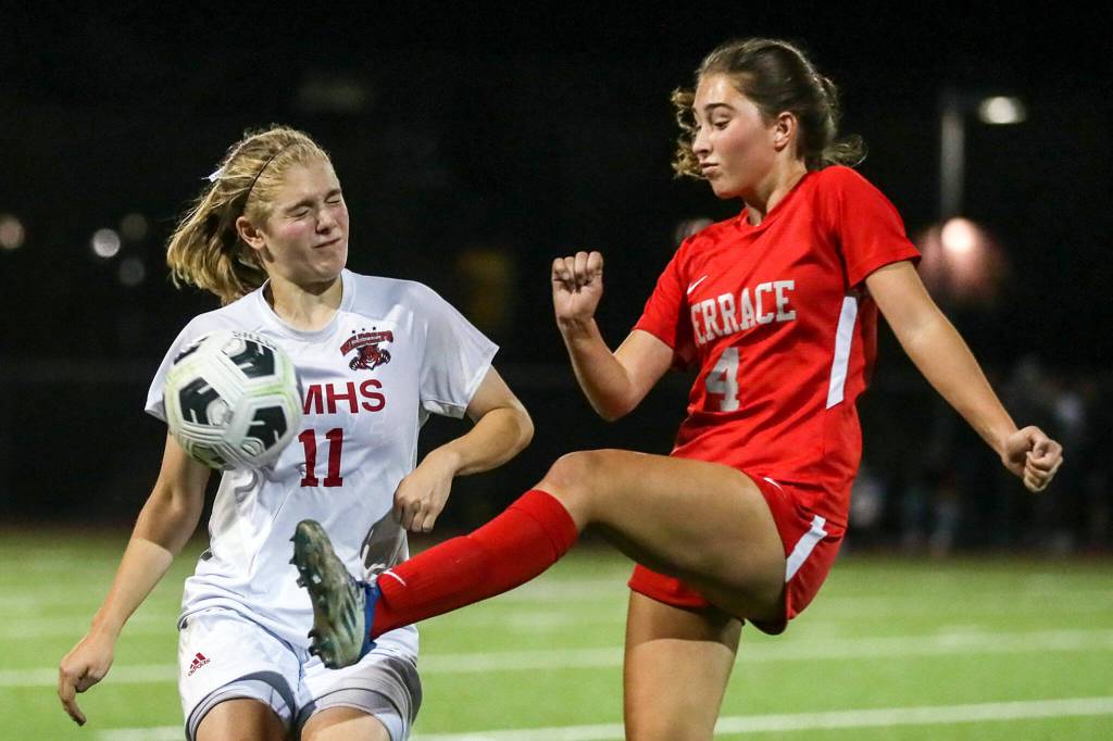 Archbishop Murphys Georgia Franck, left, Mountlake Terraces Claire August vie for control of a loose ball Thursday night at Lynnwood High School in Lynnwood, Washington on September 22, 2022. The Hawks and Wildcats finished the match with 1-1 tie. (Kevin Clark / The Herald)