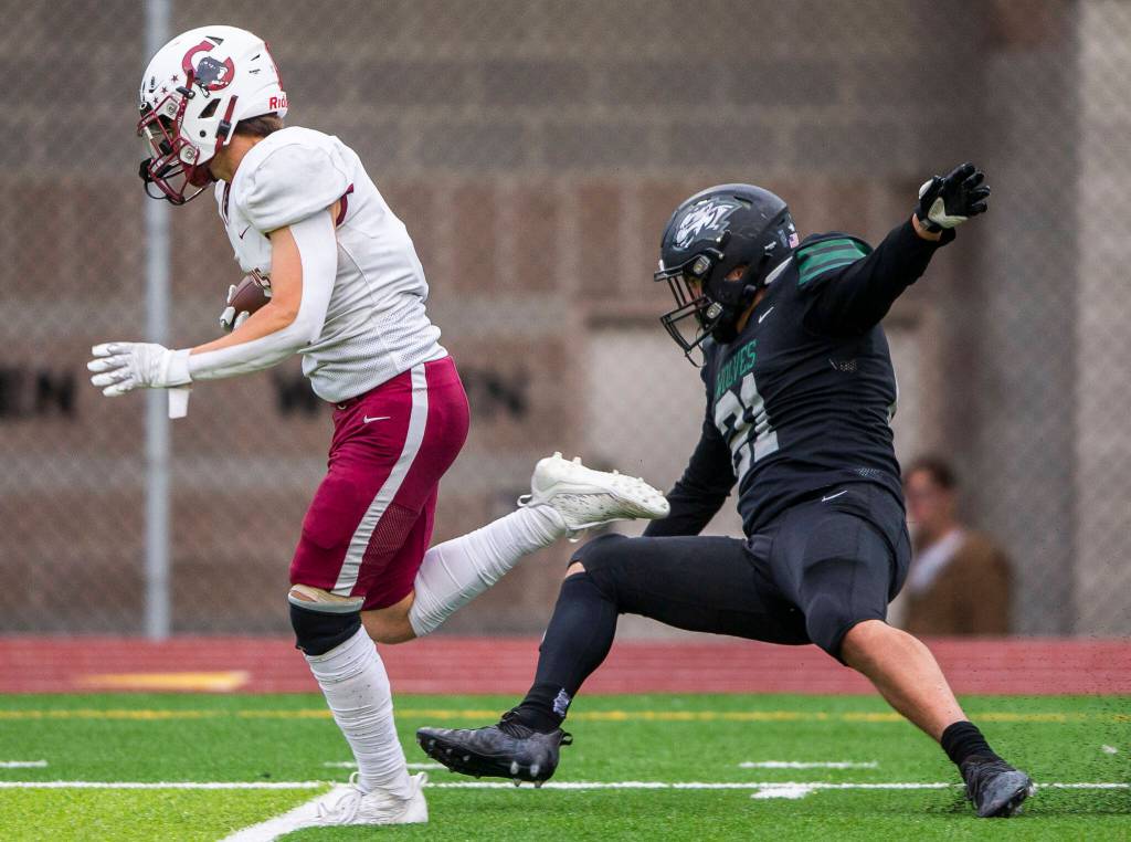 Cascades Charlie Nelson throws off a tackle to run the ball in for a touchdown during the game against Jackson on Friday, Sept. 23, 2022 in Everett, Washington. (Olivia Vanni / The Herald)