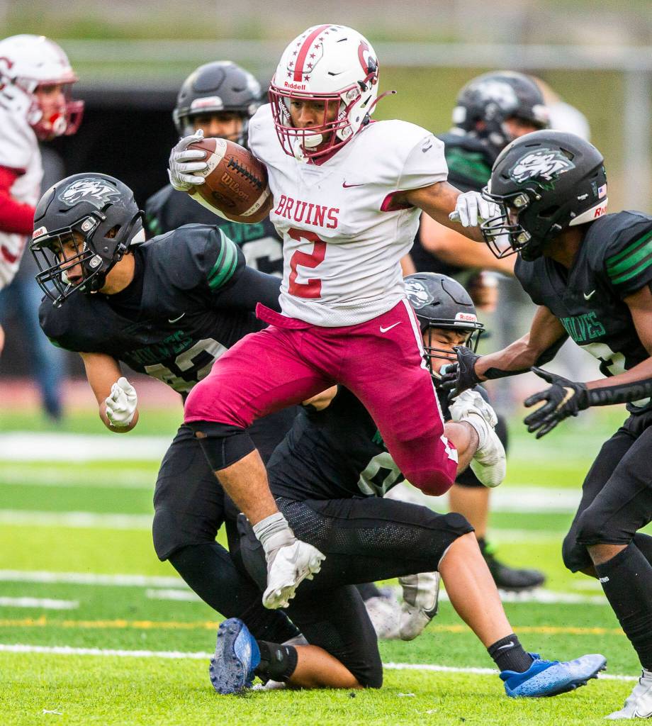 Cascades Julian Thomas jumps over multiple tackles during the game against Jackson on Friday, Sept. 23, 2022 in Everett, Washington. (Olivia Vanni / The Herald)