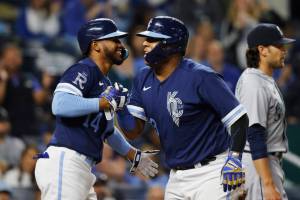 Kansas City Royals' Edward Olivares (14) congratulates Salvador Perez, right, after Perez scored from second off a Vinnie Pasquantino single during the seventh inning of a baseball game against the Seattle Mariners in Kansas City, Mo., Friday, Sept. 23, 2022. (AP Photo/Colin E. Braley)