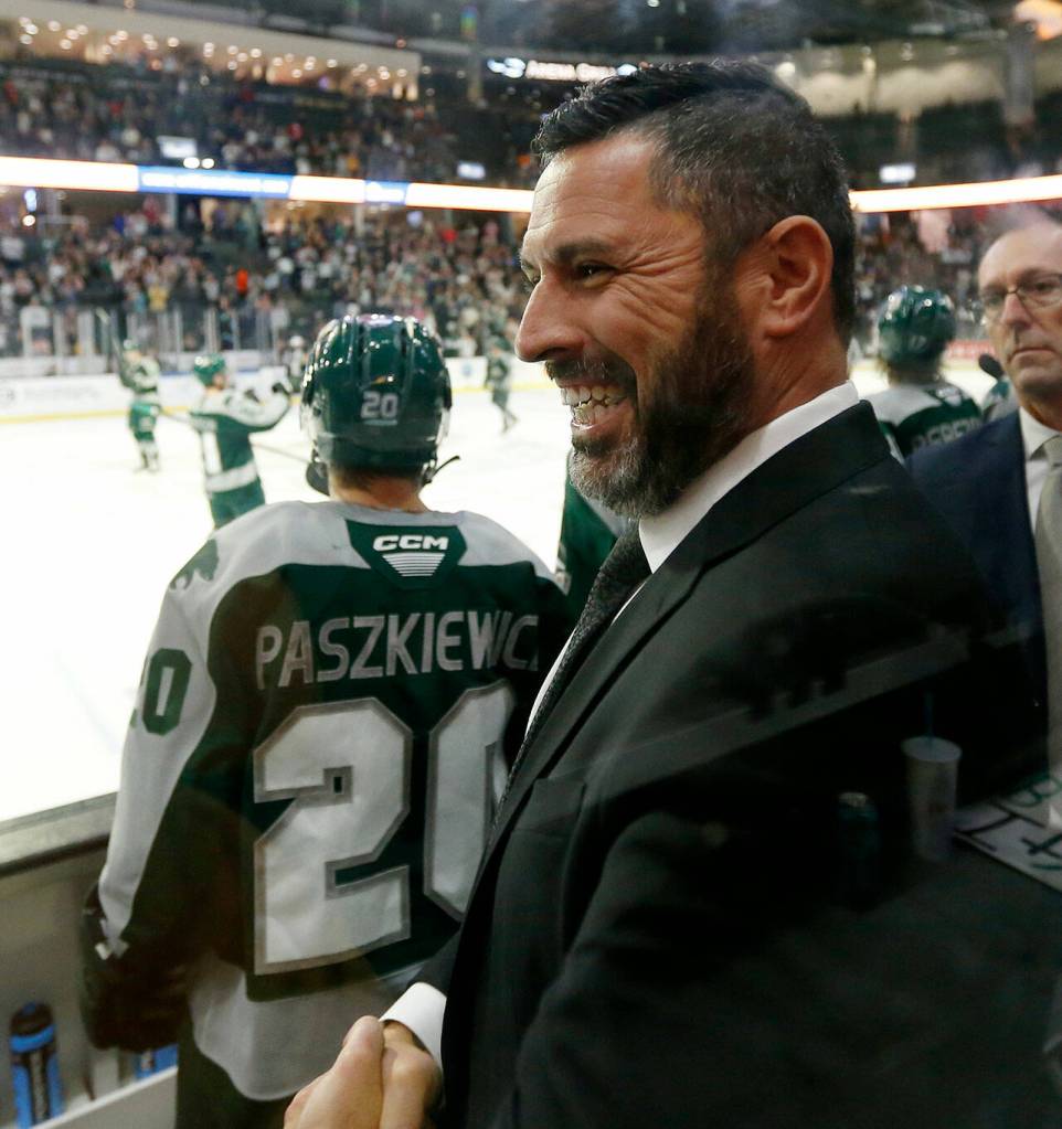 Dennis Williams, head coach and GM of the Everett Silvertips, shakes hands with an assistant coach at the end of a season opening victory over the Vancouver Giants on Saturday, Sep. 24, 2022, at Angel of the Winds Arena in Everett, Washington. (Ryan Berry / The Herald)