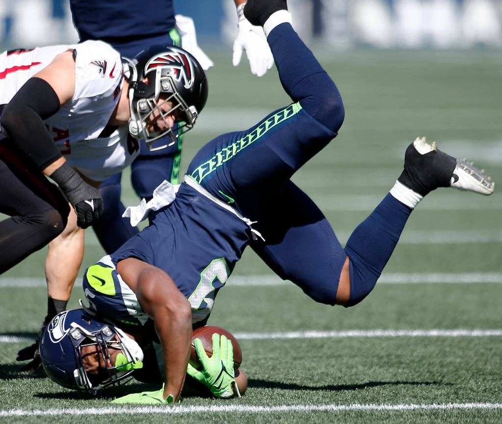 The Seattle Seahawks Kenneth Walker III gets flipped on his head while being tackled against the Atlanta Falcons on Sunday, Sep. 25, 2022, at Lumen Field in Seattle, Washington. (Ryan Berry / The Herald)