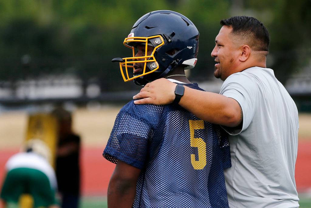 First-year Mariner football head coach Tyler Tuiasosopo talks with senior Cartez Williams during his teams practice Aug. 18 at Mariner High School in Everett. (Ryan Berry / The Herald)