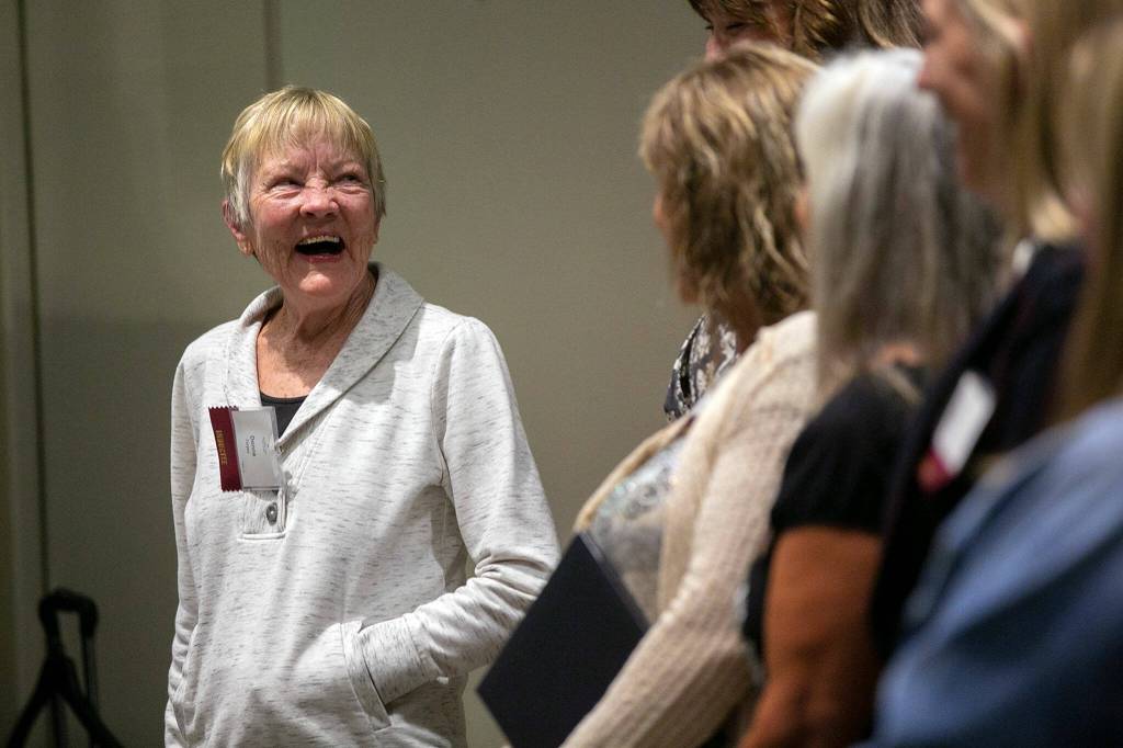 Donna Torpey, head coach of the 1982 Arlington girls basketball team, laughs with her former players during a speech at the 2022 Snohomish County Sports Hall of Fame banquet Wednesday, Sep. 28, 2022, at the Edward D. Hansen Conference Center in Everett, Washington. (Ryan Berry / The Herald)