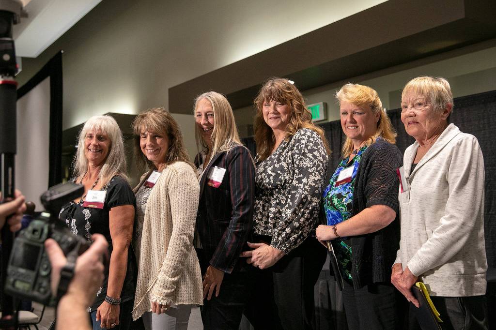 Members of the 1982 Arlington girls basketball team take a photo together during the 2022 Snohomish County Sports Hall of Fame banquet Wednesday, Sep. 28, 2022, at the Edward D. Hansen Conference Center in Everett, Washington. (Ryan Berry / The Herald)