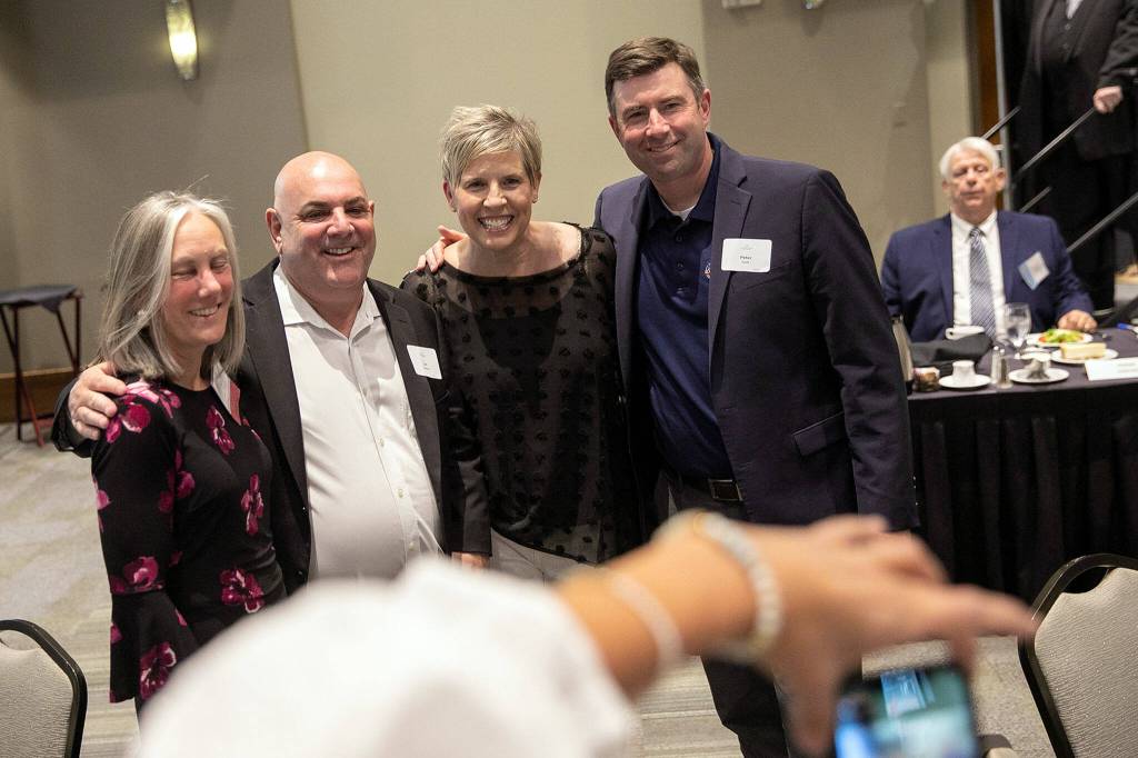 Hall of Fame inductee Carol Quarterman Kummerle, third from left, takes a group photo during the 2022 Snohomish County Sports Hall of Fame banquet Wednesday, Sep. 28, 2022, at the Edward D. Hansen Conference Center in Everett, Washington. (Ryan Berry / The Herald)