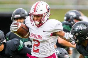 Cascade's Julian Thomas jumps over multiple tackles during the game against Jackson on Friday, Sept. 23, 2022 in Everett, Washington. (Olivia Vanni / The Herald)