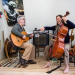 Phil Spirito and his wife, Libby Reed, play a song together in their home in Monroe. (Olivia Vanni / The Herald)