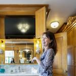 Brenda Kerr shows off her hidden television in the master bath at her home, the Rucker Mansion, on Oct. 11 in Everett. (Kevin Clark / The Herald)