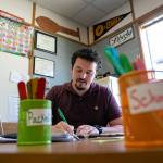 Zachary Pfrimmer grades assignments while his students work with another teacher in his fourth-grade classroom at Cedarhome Elementary on Sep. 21, in Stanwood. (Ryan Berry / The Herald)