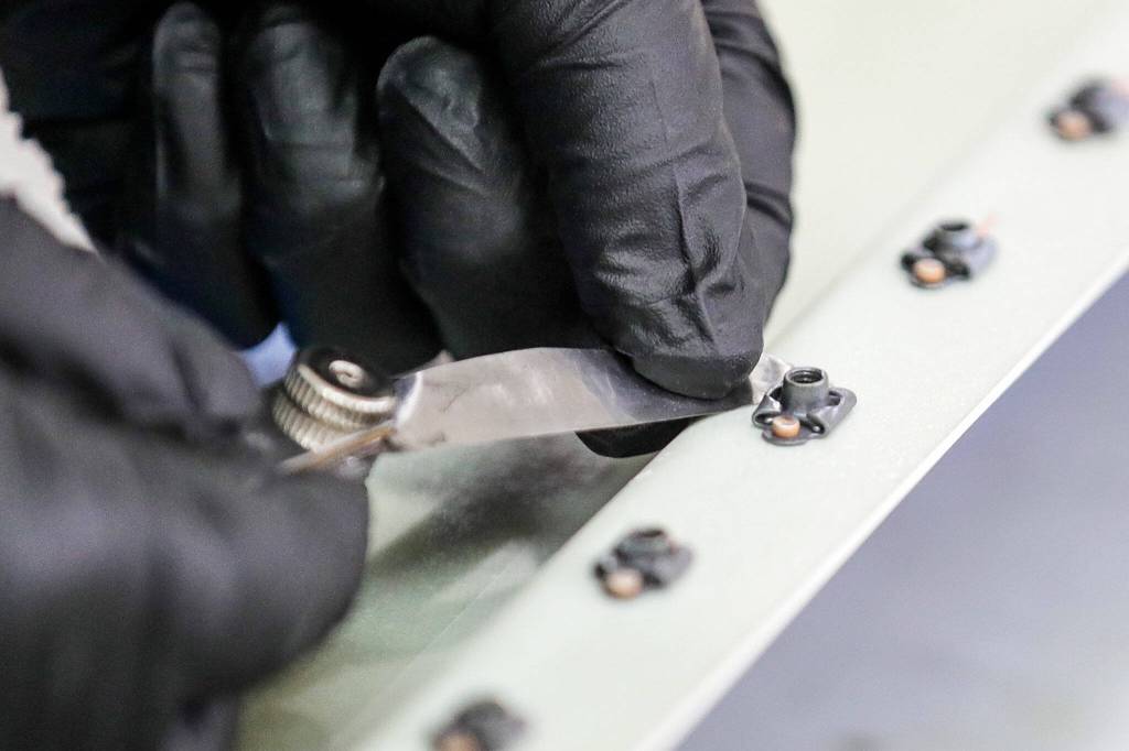 A student measures the spacing between a rivet on Sept. 23, at Pathfinder Manufacturing in Everett. (Kevin Clark / The Herald)