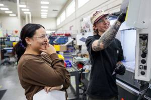 Analisa Paterno of Marysville-Getchell, left, shares a laugh with Nathan Harms Friday morning at Pathfinder Manufacturing in Everett, Washington on September 23, 2022.  (Kevin Clark / The Herald)
