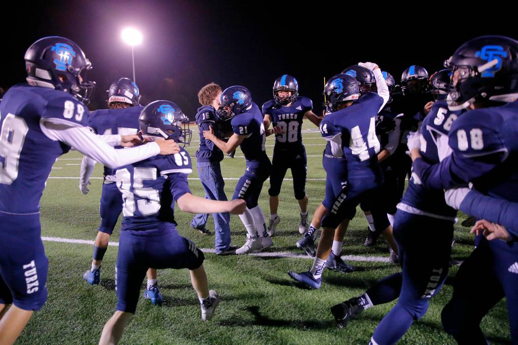 The Sultan Turks storm the field after winning the Black and Blue Bowl over Granite Falls 16-13 on Friday, Sep. 30, 2022, at Sultan High School in Sultan, Washington. (Ryan Berry / The Herald)