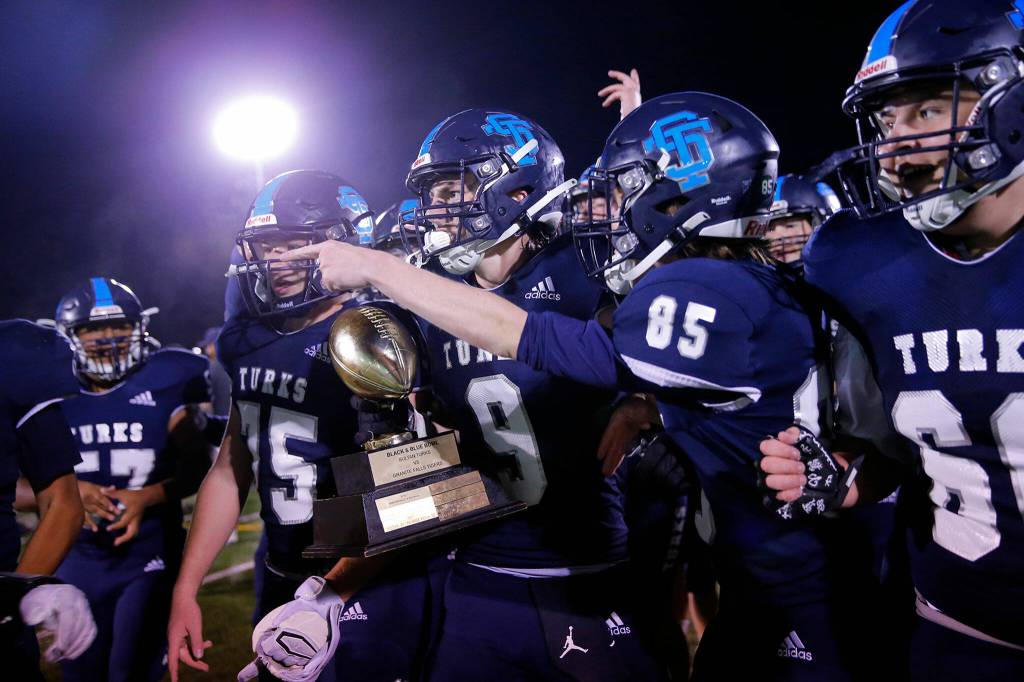 The Sultan Turks take their trophy and head for the student section after winning the Black and Blue Bowl over Granite Falls 16-13 on Friday, Sep. 30, 2022, at Sultan High School in Sultan, Washington. (Ryan Berry / The Herald)