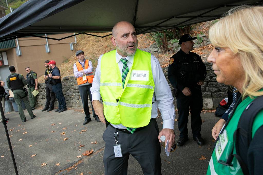 Henry M. Jackson High Principal Lance Balla keeps an eye on the simulation during an Everett Public Schools emergency drill on Thursday, at Everett Memorial Stadium in Everett. (Ryan Berry / The Herald)