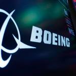 FILE - The logo for Boeing appears on a screen above a trading post on the floor of the New York Stock Exchange, Tuesday, July 13, 2021.  Boeing is behind schedule in submitting documentation for new versions of its 737 Max jetliner, and it's asking Congress for more time. Federal officials say Boeing has completed little of the work necessary to certify the new Max versions by a Dec. 31, 2022 deadline. (AP Photo/Richard Drew, file)