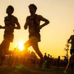 Runners in the 3A-4A Boys 5K turn a corner as the sun sets during the Nike Twilight Cross Country Invitational on Saturday, Oct. 1, 2022, at Cedarcrest Golf Course in Marysville, Washington. (Ryan Berry / The Herald)