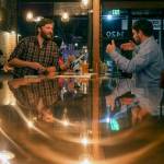 Colin Lothrop, left, talks with Sean Curran at Toggles Bootleshop in Everett on Nov. 8, 2017. (Kevin Clark / The Herald)