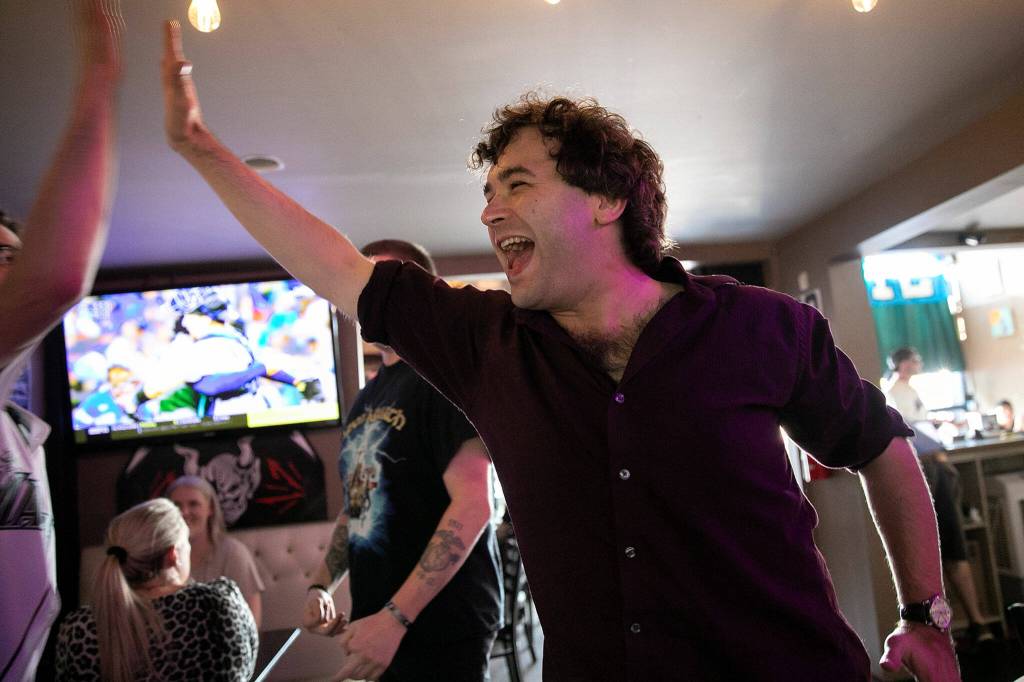 Matthew Kenyon, 33, doles out some high fives after the Mariners Wildcard Game 1 win over the Toronto Blue Jays on Friday, at Brews Almighty® in Everett. (Ryan Berry / The Herald)