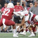 Washington State linebacker Travion Brown (82) and defensive back Armani Marsh (8) tackle California running back Jaydn Ott (6) during the second half of a game Oct. 1 in Pullman. (AP Photo/Young Kwak)
