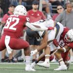 Washington State linebacker Travion Brown (82) and defensive back Armani Marsh (8) tackle California running back Jaydn Ott (6) during the second half of an NCAA college football game, Saturday, Oct. 1, 2022, in Pullman, Wash. (AP Photo/Young Kwak)