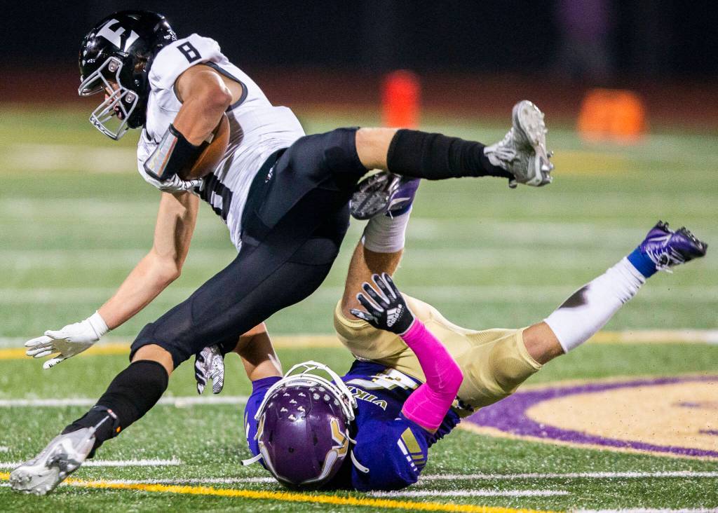 Eastlakes Grady Woodward falls after being tackled by Lake Stevens Gabe Kylany during the game on Friday, Oct. 7, 2022 in Lake Stevens, Washington. (Olivia Vanni / The Herald)
