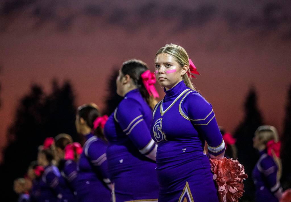A Lake Stevens cheerleader waits for the start of the game against Eastlake on Friday, Oct. 7, 2022 in Lake Stevens, Washington. (Olivia Vanni / The Herald)