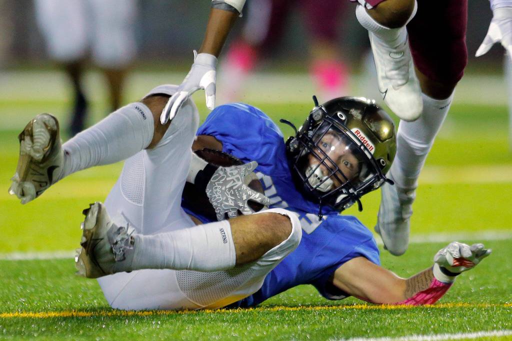 Everetts Josh Smith tumbles forward after a diving catch during the Battle of Broadway against Cascade on Friday, Oct. 7, 2022, at Everett Memorial Stadium in Everett, Washington. (Ryan Berry / The Herald)