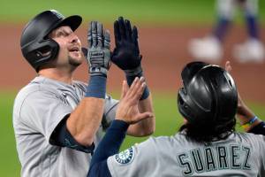 Seattle Mariners' Cal Raleigh (29) and teammate Eugenio Suarez (28) celebrate Raleigh's two-run home run during the first inning in Game 1 of a AL wild card baseball playoff series against the Toronto Blue Jays in Toronto on Friday, Oct. 7, 2022. (Frank Gunn/The Canadian Press via AP)