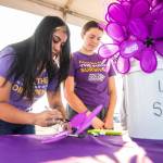 Sarah and Kayla Van Den Dyssel make a flower to remember their Grandpa Eli on Saturday during the annual Walk to End Alzheimers at Boxcar Park in Everett. (Olivia Vanni / The Herald)