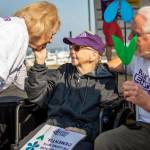 Jenny Duffey, center, touches the face of Katie Rielinger, her friend of more than 20 years, during the annual Walk to End Alzheimers on Saturday at Boxcar Park in Everett. (Olivia Vanni / The Herald)