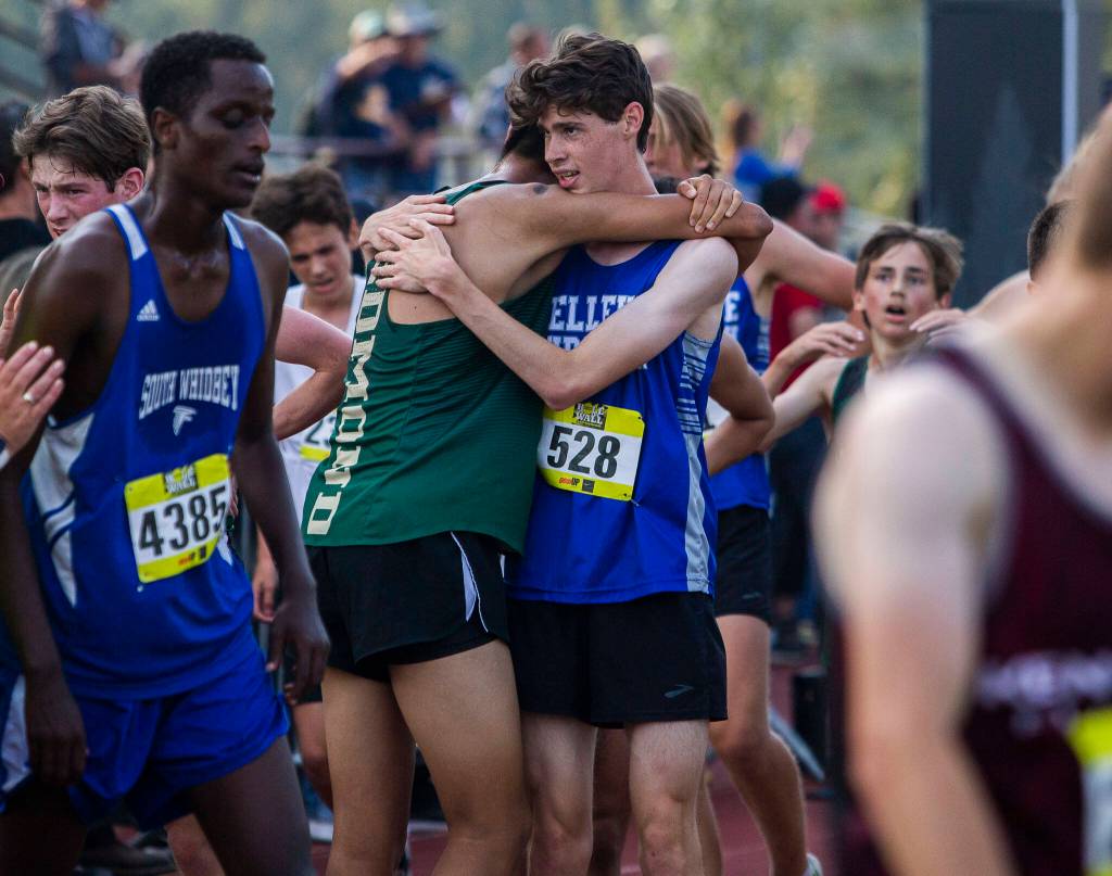 Runners hug after finishing their race at the Hole In The Wall Invitational on Saturday, Oct. 8, 2022 in Arlington, Washington. (Olivia Vanni / The Herald)