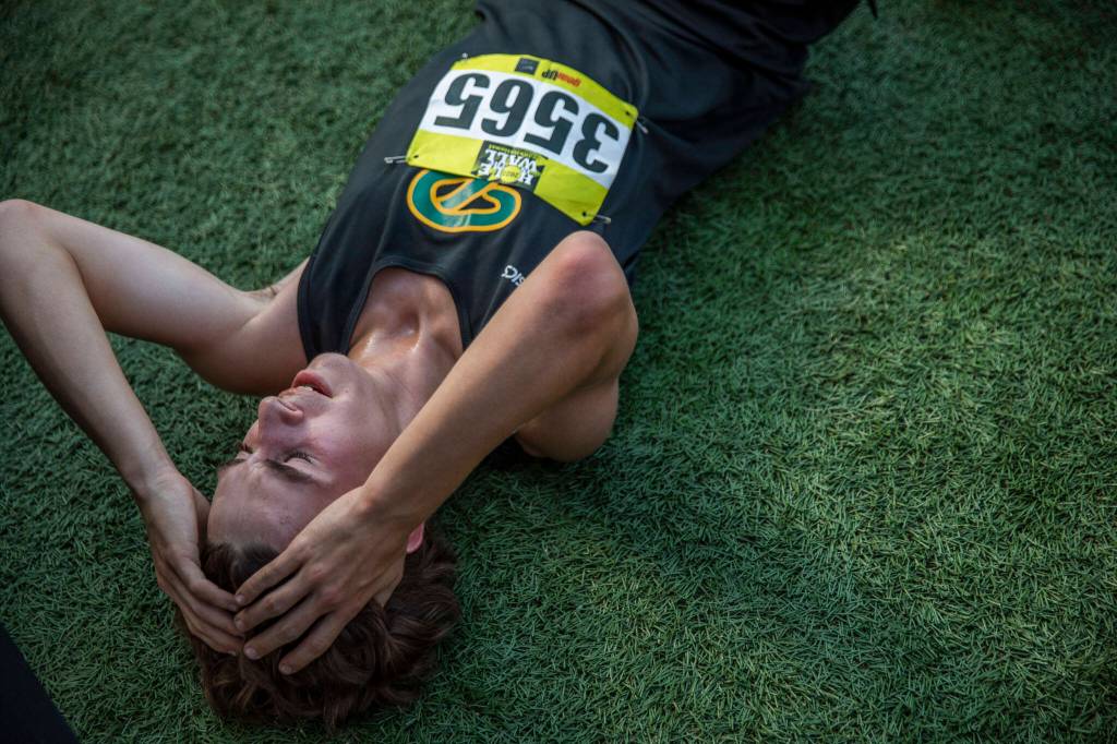 A Roosevelt runner lies on the ground after finishing their race at the Hole In The Wall Invitational on Saturday, Oct. 8, 2022 in Arlington, Washington. (Olivia Vanni / The Herald)