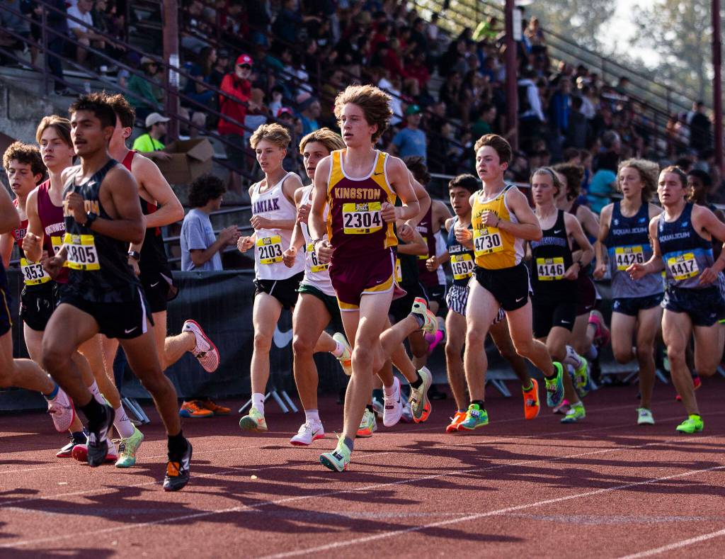 Boys varsity gold runners make their way off of the track during their first lap at the Hole In The Wall Invitational on Saturday, Oct. 8, 2022 in Arlington, Washington. (Olivia Vanni / The Herald)