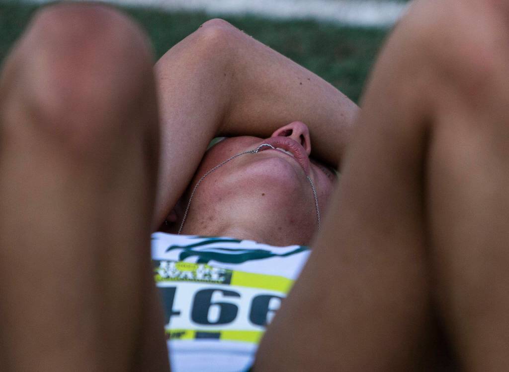 A runner bites down on their necklace and cries after finishing their race at the Hole In The Wall Invitational on Saturday, Oct. 8, 2022 in Arlington, Washington. (Olivia Vanni / The Herald)