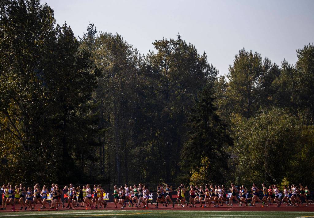 Runners make their way around the corner of the track at the Hole In The Wall Invitational on Saturday, Oct. 8, 2022 in Arlington, Washington. (Olivia Vanni / The Herald)