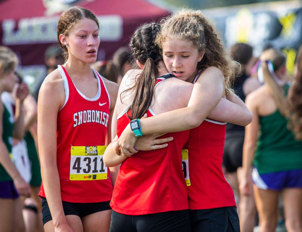 Snohomish runners hug each other after their races at the Hole In The Wall Invitational on Saturday, Oct. 8, 2022 in Arlington, Washington. (Olivia Vanni / The Herald)