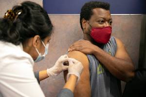 Everett resident Shon Grimes receives a flu shot from pharmacist Nisha Mathew at Bartell Drugs on Broadway on Saturday, Oct. 1, 2022, in Everett, Washington. (Ryan Berry / The Herald)