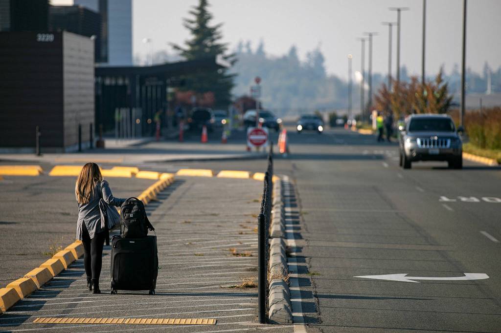 A person hauls their luggage to the terminal at Paine Field on Thursday, in unincorporated Snohomish County. (Ryan Berry / The Herald)