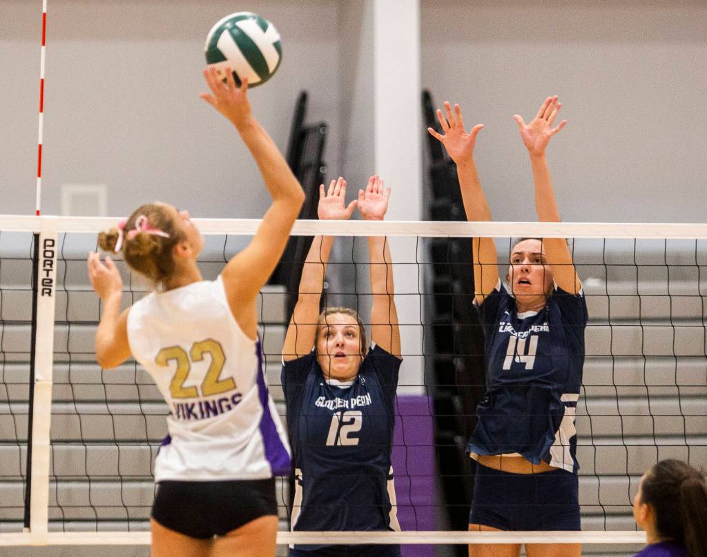 Glaicer Peaks Julia Martin and Addison Ordonez jump to block a spike from Lake Stevens Laura Eichert during the match on Tuesday, Oct. 11, 2022 in Lake Stevens, Washington. (Olivia Vanni / The Herald)