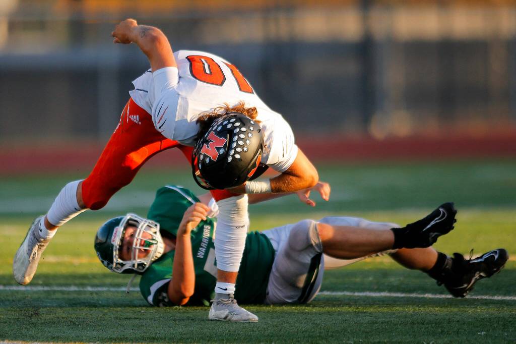 Monroes Blake Springer barely evades pressure from Reed Burmaster before eventually getting sacked against Edmonds-Woodway on Friday, Oct. 14, 2022, at Edmonds School District Stadium in Edmonds, Washington. (Ryan Berry / The Herald)