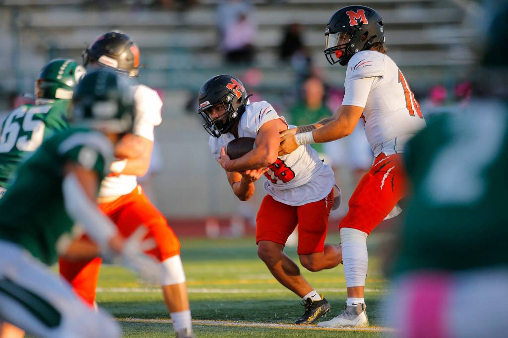 Monroes Beau Pruett takes a handoff against Edmonds-Woodway on Friday, Oct. 14, 2022, at Edmonds School District Stadium in Edmonds, Washington. (Ryan Berry / The Herald)