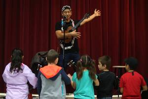 Jake Shimabukuro, a renowned ukulele player, shows students how to strum an open chord with one hand at Frank Wagner Elementary on Monday, Oct. 14, 2019 in Monroe, Wash. The school started a ukulele program last year and recently got grant money for new instruments. (Andy Bronson / The Herald)