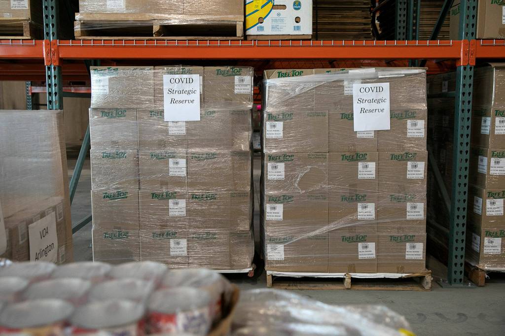 Boxes from the COVID strategic reserve are stored away in the warehouse Thursday, at the Volunteers of America food distribution center in Arlington. (Ryan Berry / The Herald)