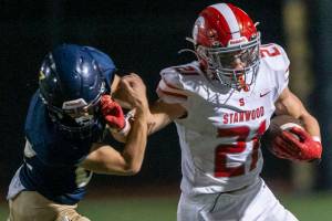 Stanwood’s Otto Wiedmann reacts out to block a tackle during the Stilly Cup against Arlington on Friday, Sept. 30, 2022 in Arlington, Washington. (Olivia Vanni / The Herald)