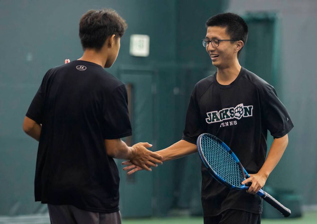 Jacksons David Song and Henry Park high five during the 4A doubles final on Thursday, Oct. 20, 2022 in Everett, Washington. (Olivia Vanni / The Herald)