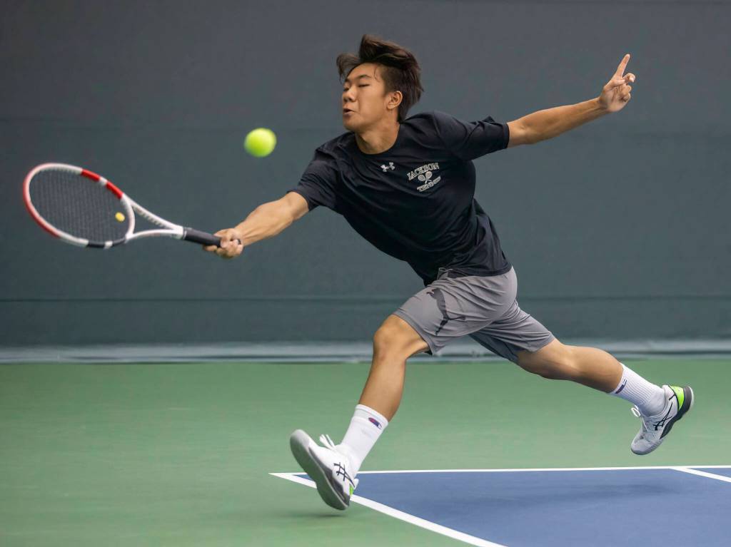 Jackson’s David Song dives to hit the ball during the 4A doubles final on Thursday, Oct. 20, 2022 in Everett, Washington. (Olivia Vanni / The Herald)